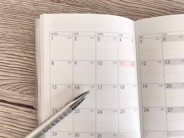 暦を書いた手帳とペン